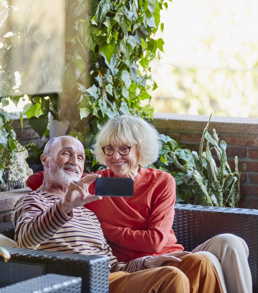Happyn senior couple taking a selfie smiling on a balcony